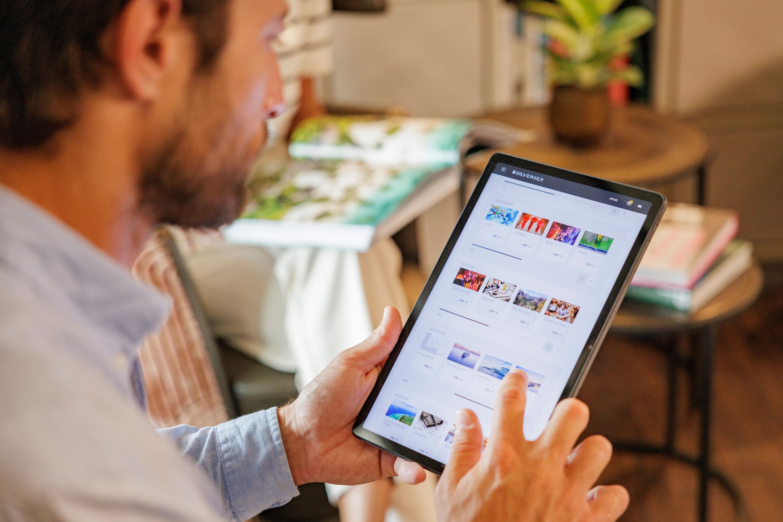 A man looking at booking a cruise on a tablet